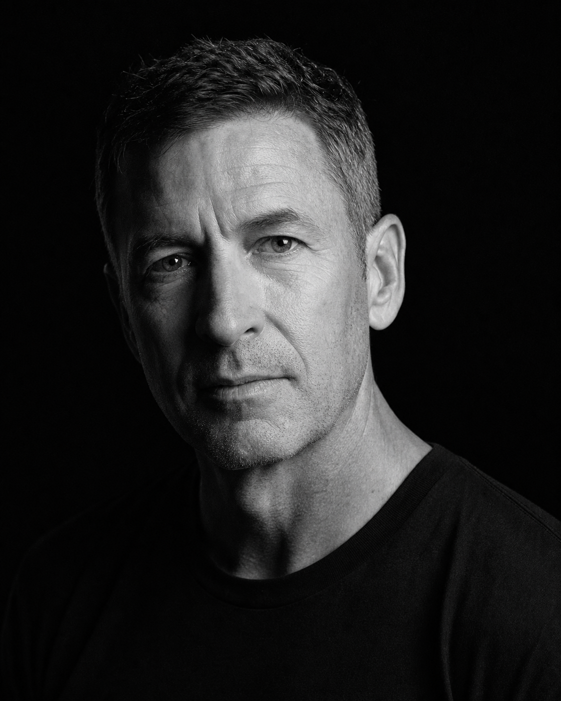 Portrait studio en noir et blanc d’un homme éclairé de côté
